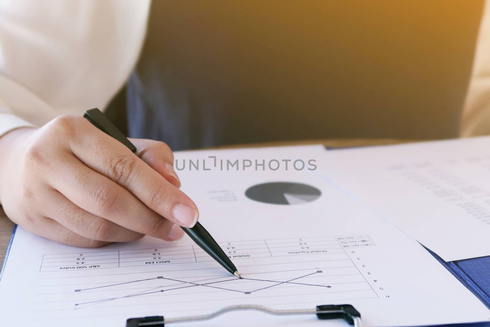 Businesswoman analyzing investment charts and pressing calculator buttons over documents. Accounting Concept