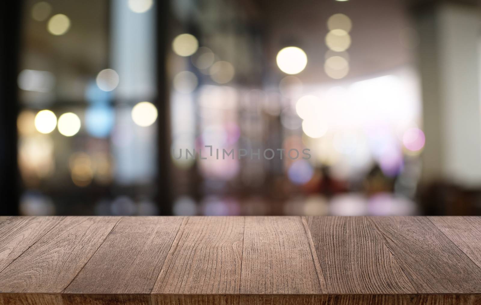 Empty dark wooden table in front of abstract blurred bokeh background of restaurant . can be used for display or montage your products.Mock up for space