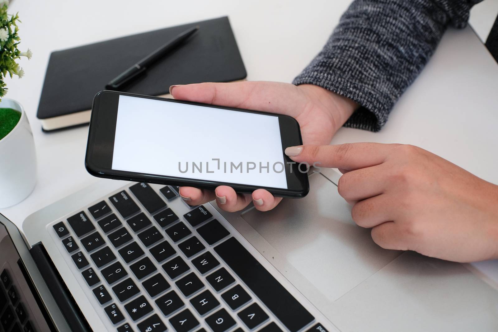 girl using smart phone in office. hand holding smart phone white screen.