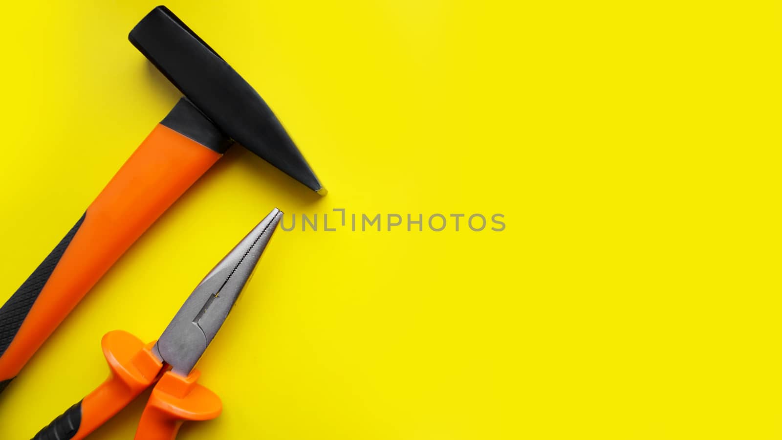 Tools worker, hammer, pliers on bright yellow background, top view by natali_brill