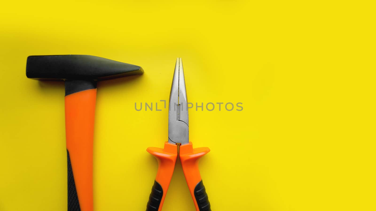 Tools worker, hammer, pliers on bright yellow background, top view. Repair tools