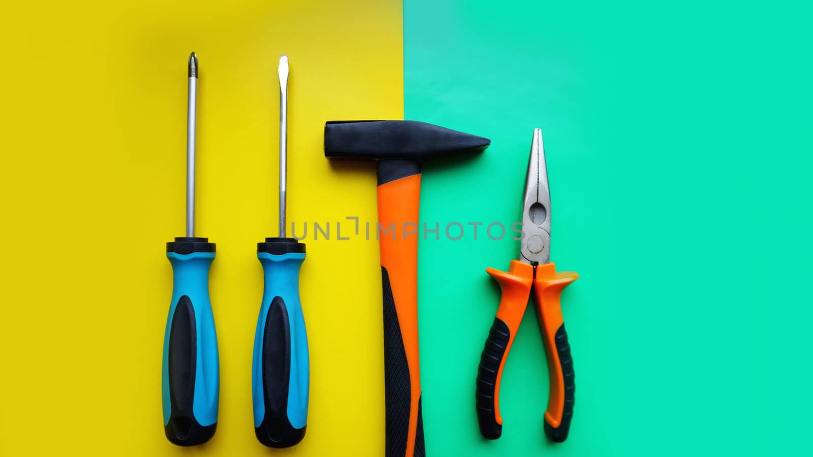 Tools worker, hammer, screwdrivers, pliers on bright yellow and blue background by natali_brill