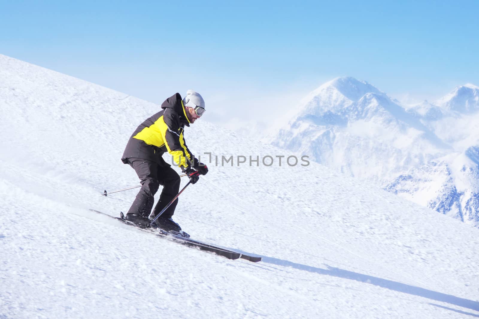 Alpine skier on piste running downhill by destillat