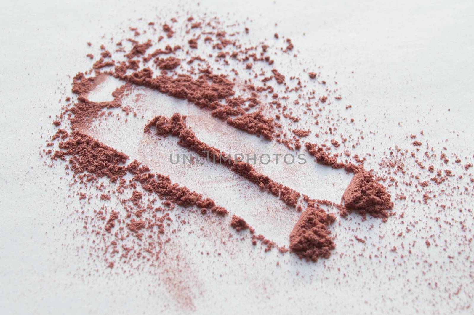 Scattered beige powder, Crumbles natural makeup powder on white background.