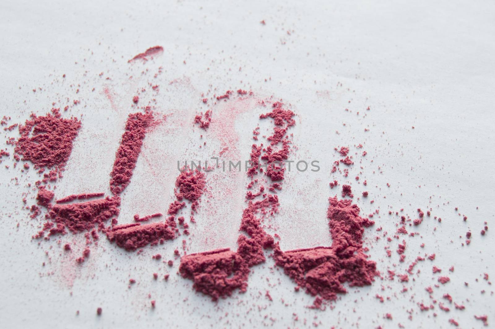 Pink blush scattered on white background, makeup background.