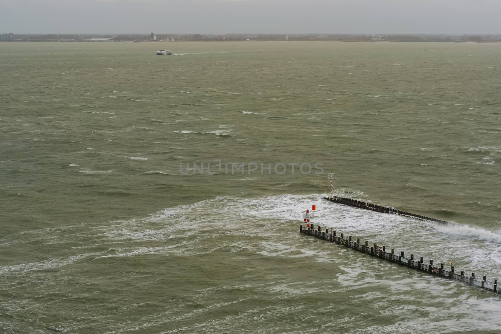 port of Vlissingen, wooden poles with watchtower and tiny lighthouse, wild sea with waves, zeeland, The netherlands