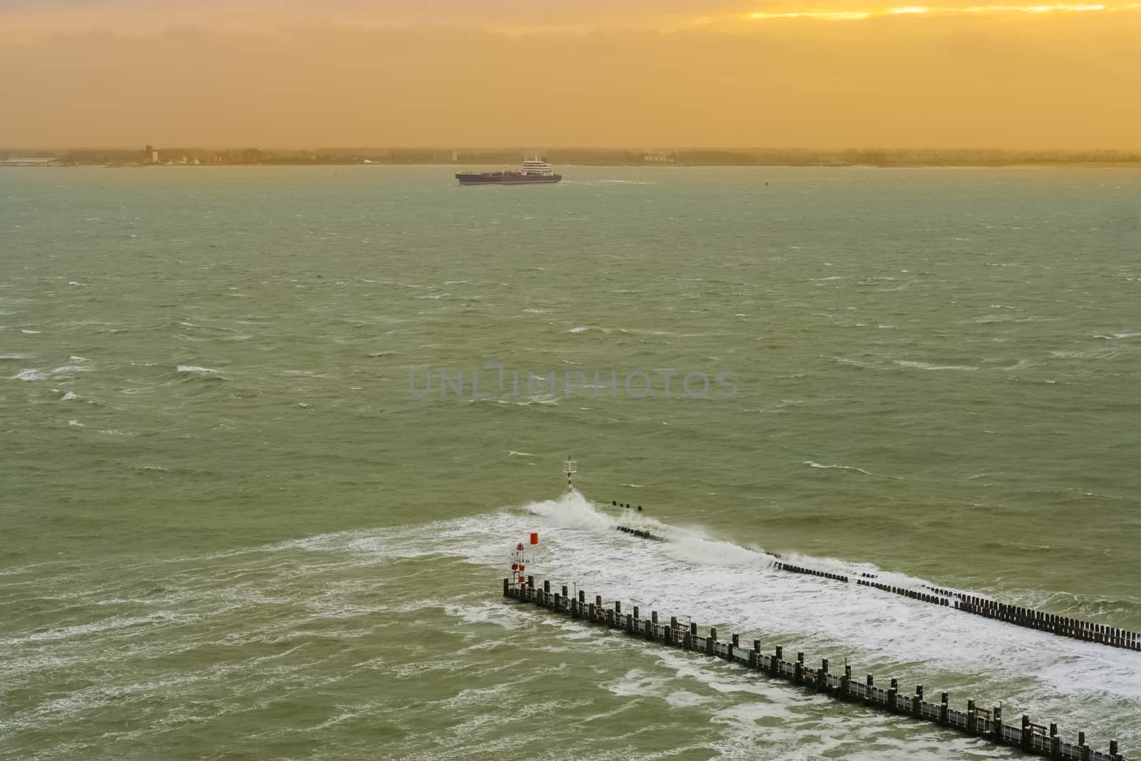 the port of vlissingen at sunset with a boat sailing by, landscape of a wild sea, Zeeland, The Netherlands