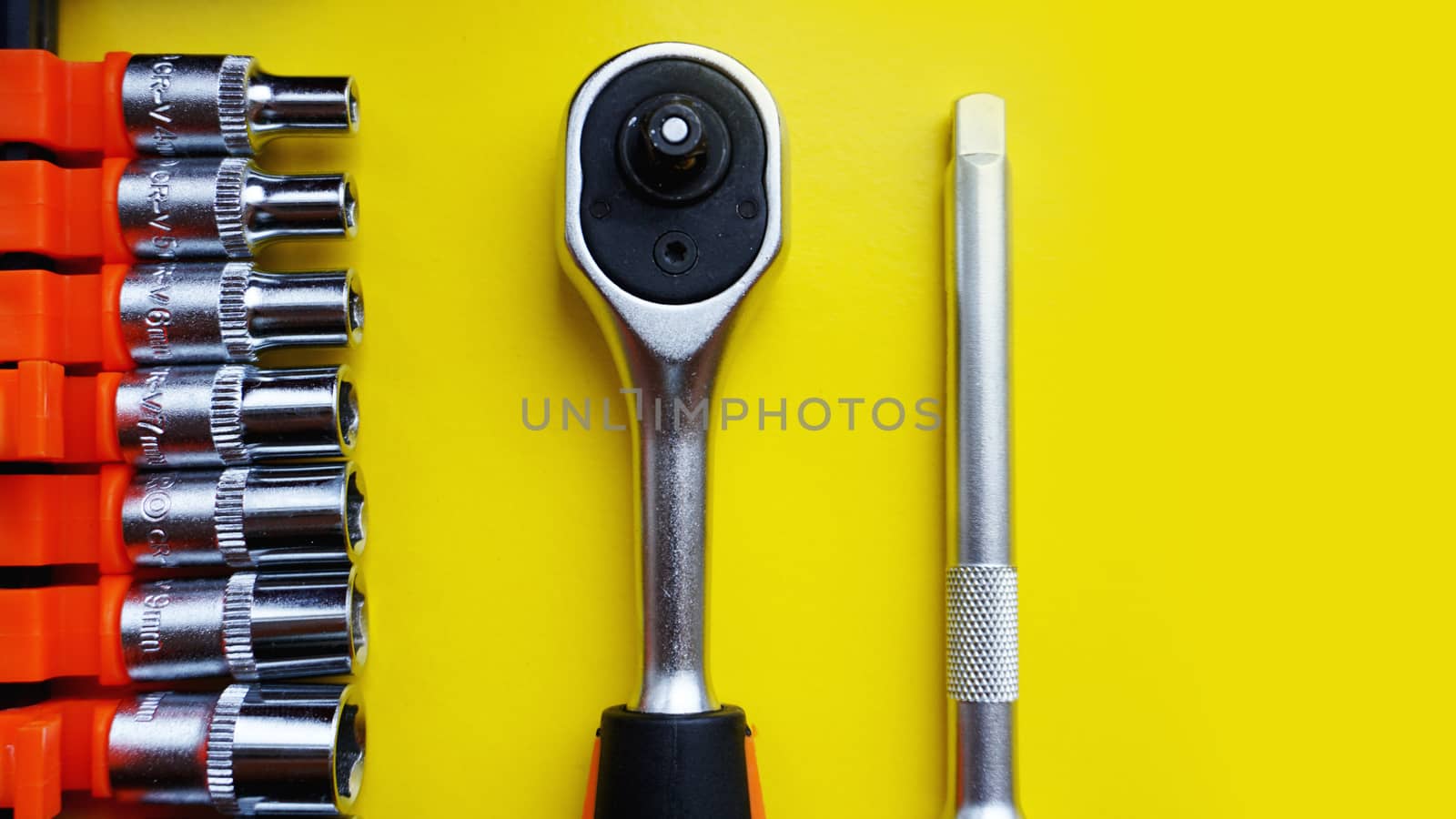 Wrench head bits for the screwdriver and other tools on bright yellow background, top view