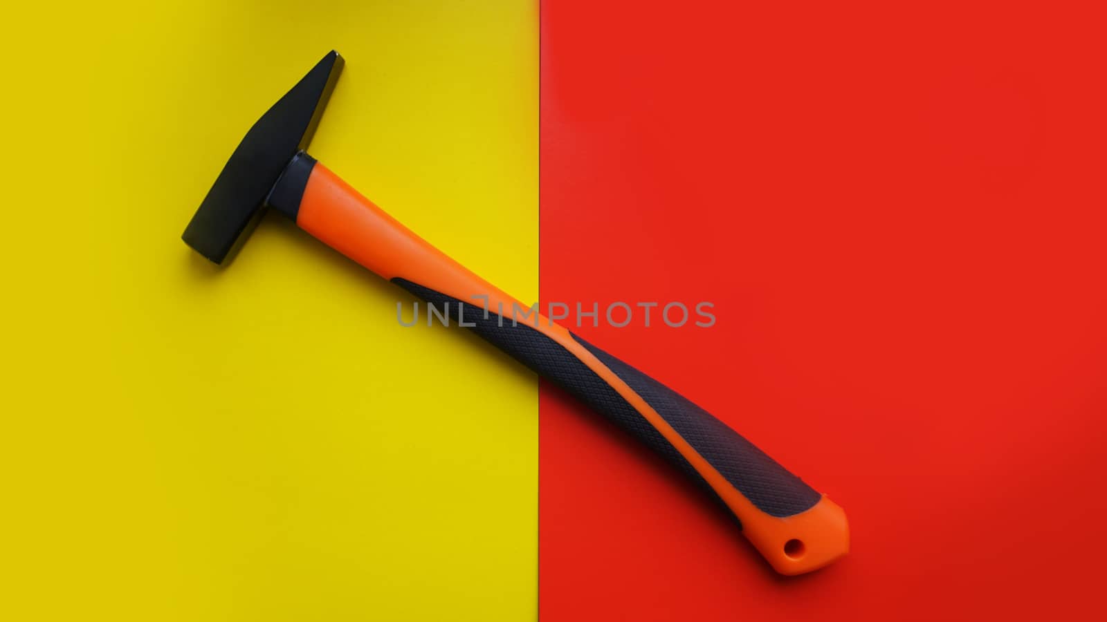 Hammer tool isolated on yellow and red background with copy space. Construction concept background.