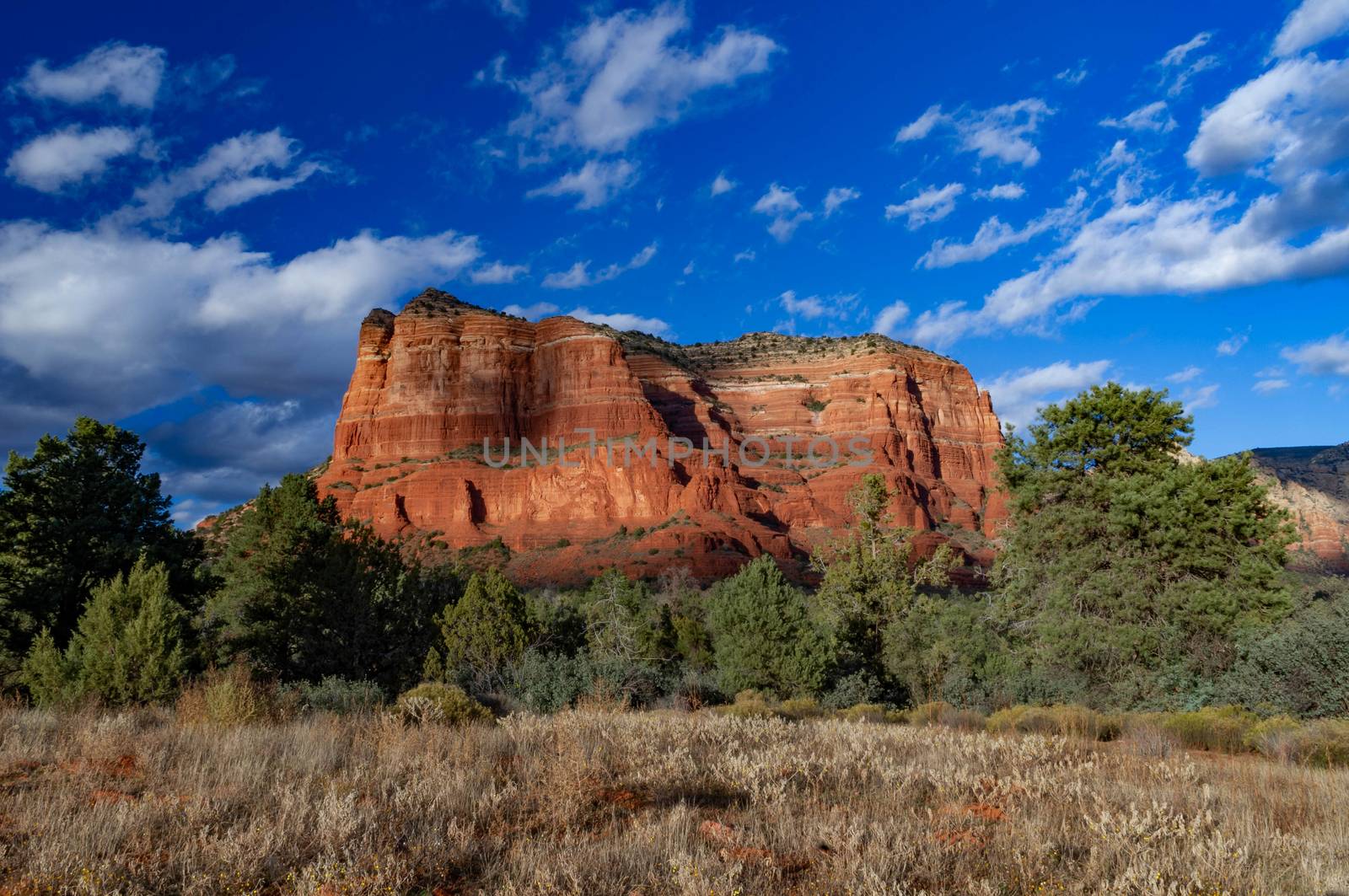 Courthouse Rock in Village of Oak Creek in Arizona with a blue sky with clouds.