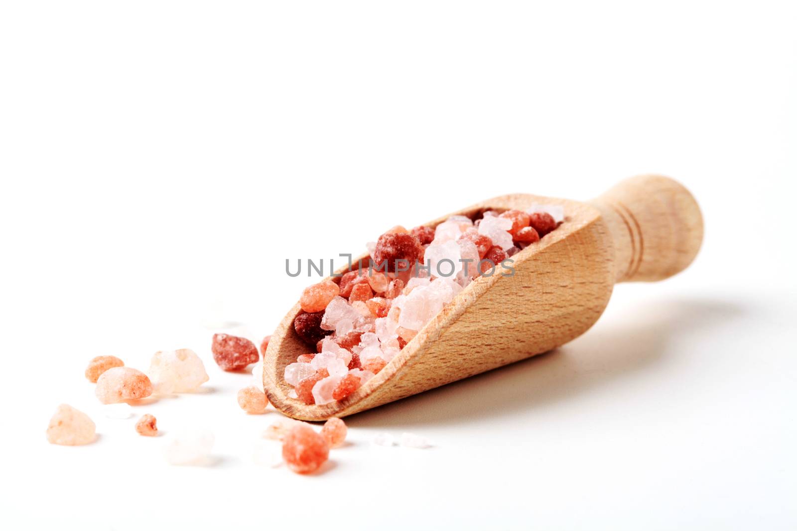 Himalaya Salt Crystals In Wood Spoon Close-up Isolated On White Background