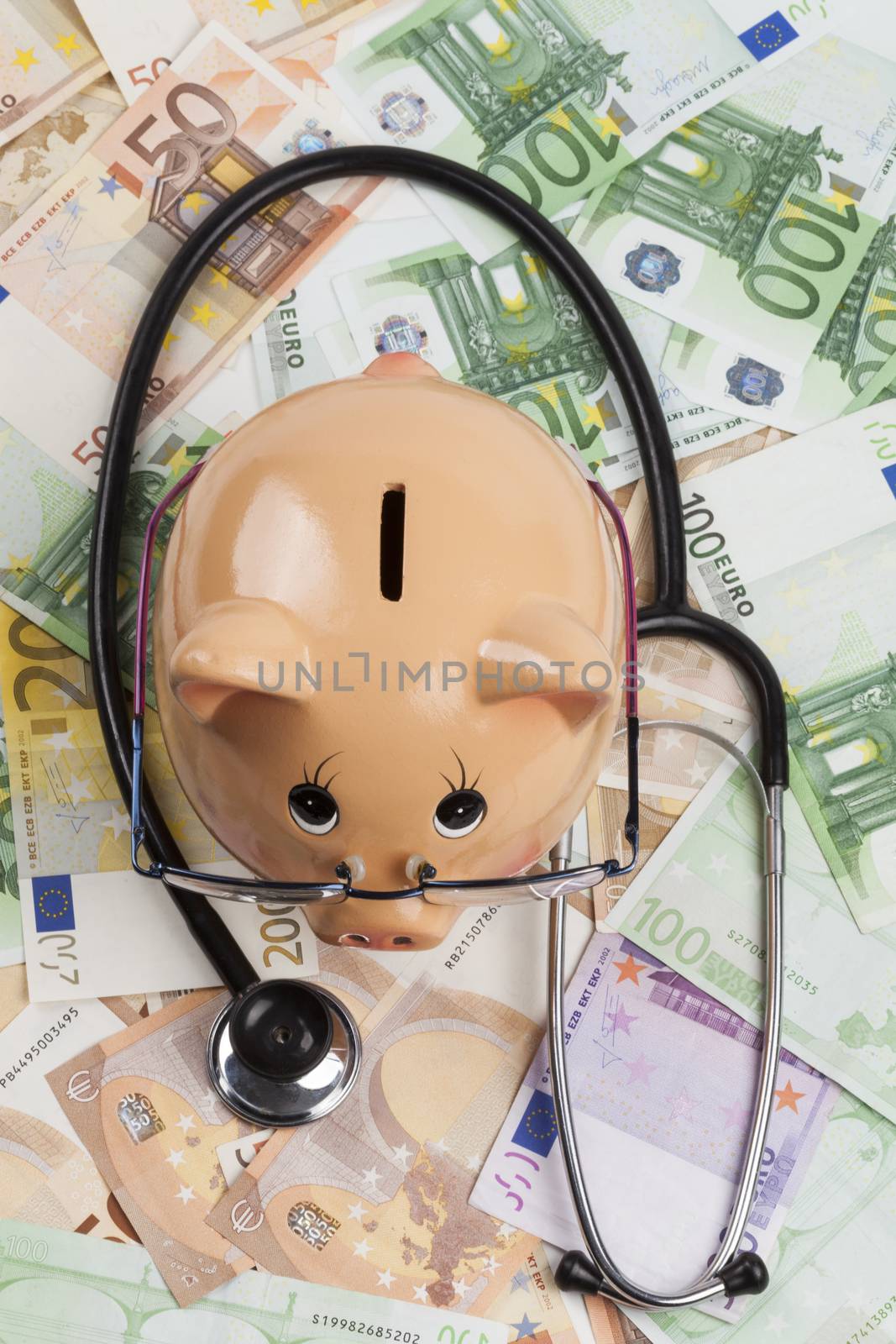 Piggy Bank With Black Stethoscope on Euro Banknotes . European Health Insurance Costs