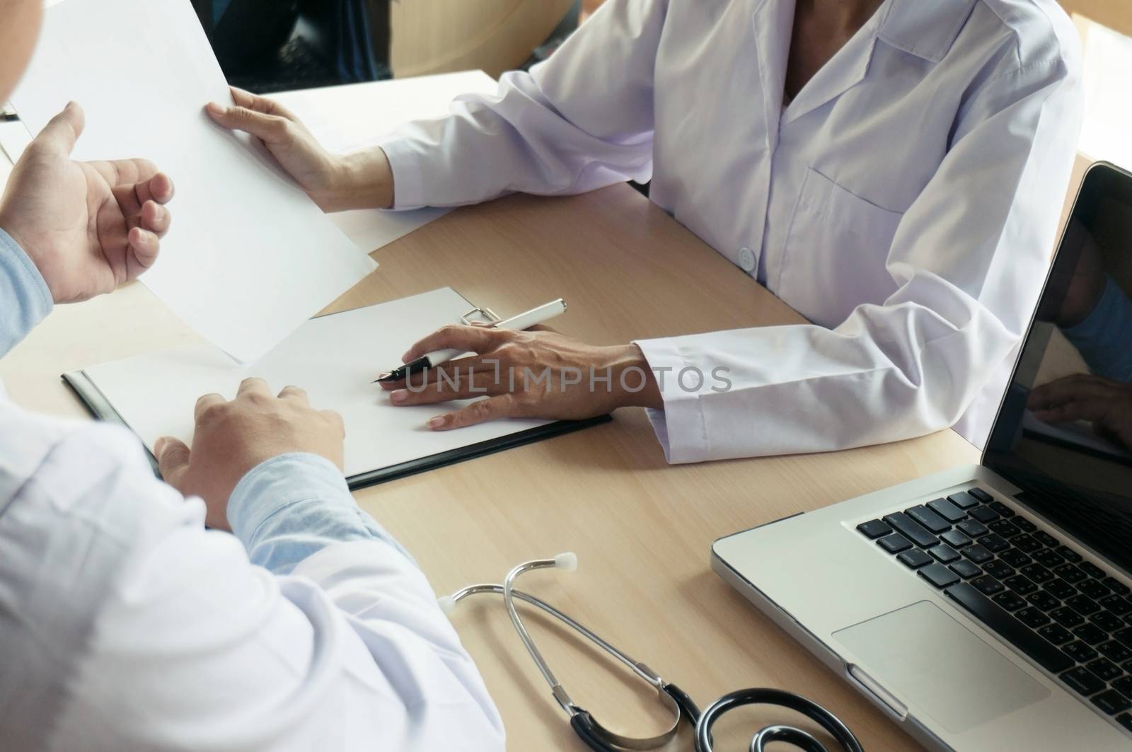 close up of patient and doctor taking notes or Professional medical doctor in white uniform gown coat interview.