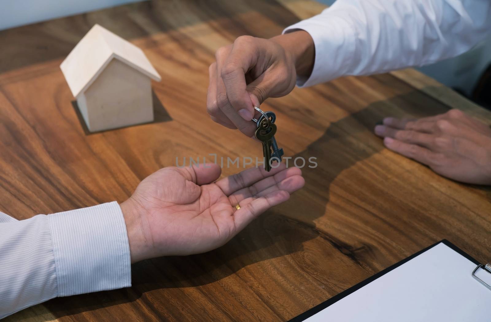 Real estate agent giving keys to customer after contract signatu by peandben