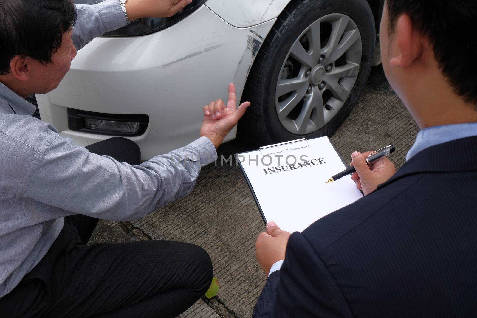 Loss Adjuster Insurance Agent Inspecting Damaged Car. by peandben