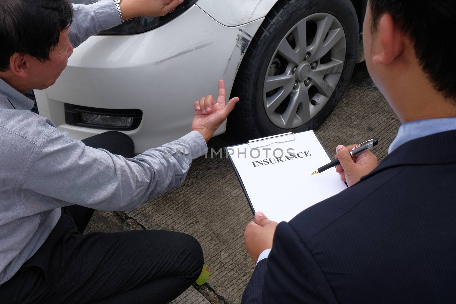 Loss Adjuster Insurance Agent Inspecting Damaged Car 