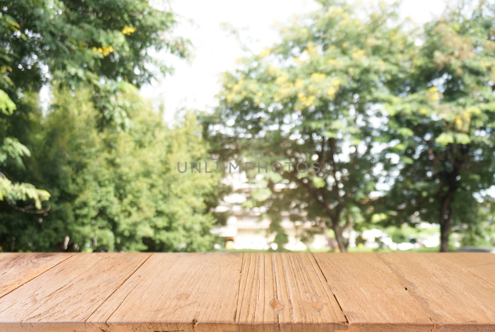 Image of wooden table in front of abstract blurred background of by peandben