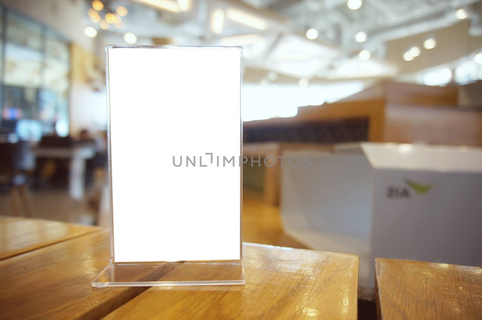 Mock up Menu frame standing on wood table in Bar restaurant cafe. space for text.