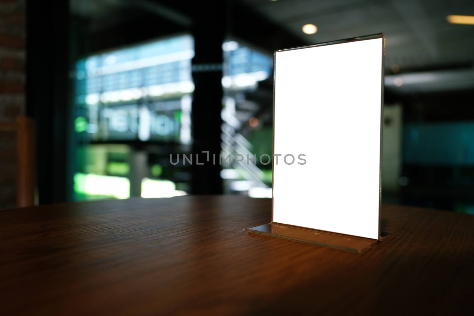 Mock up Menu frame standing on wood table in Bar restaurant cafe. space for text