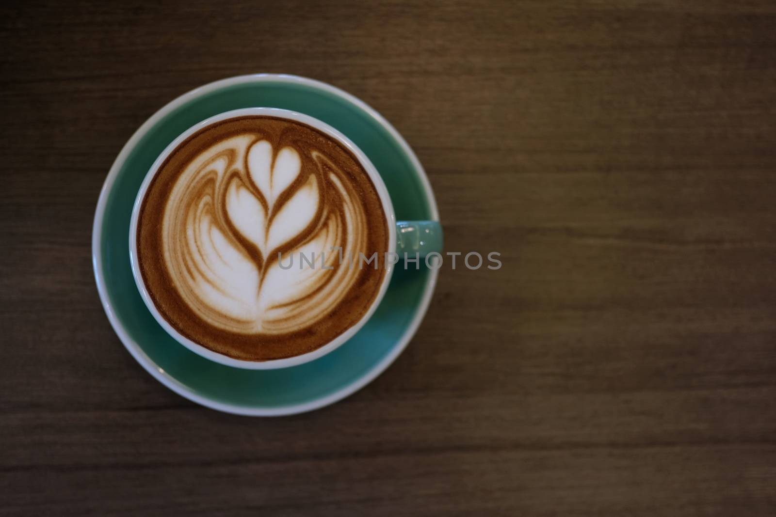 Cup of hot latte art coffee on wooden table