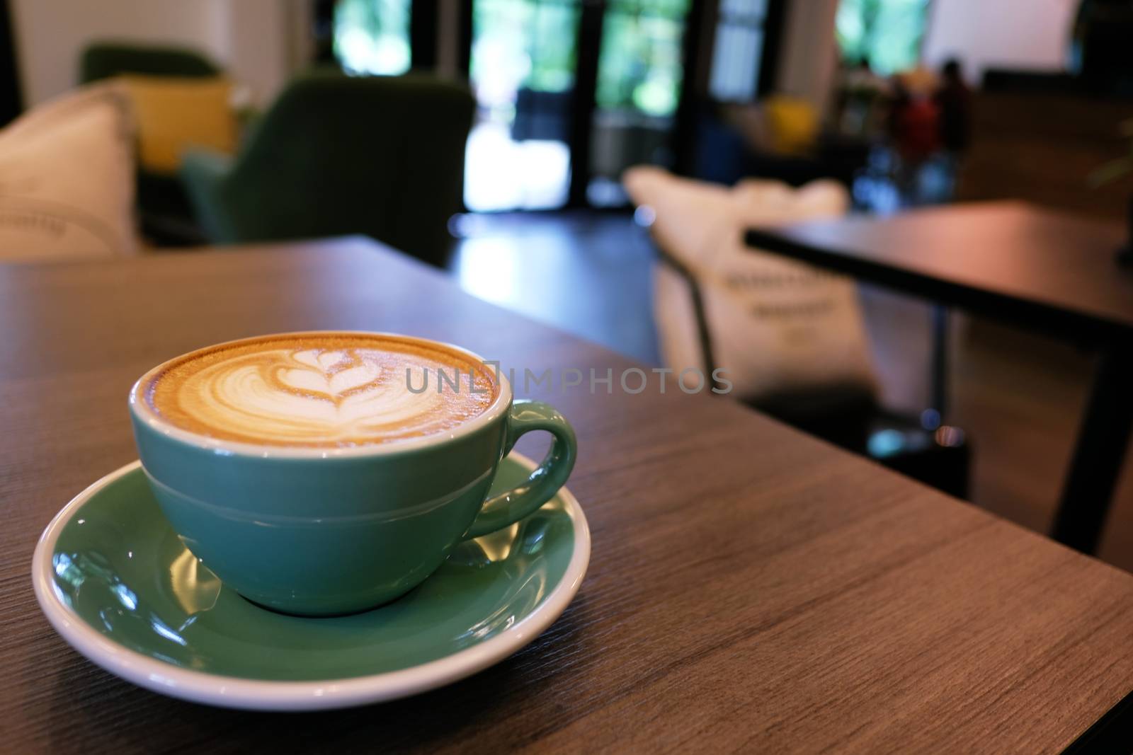 Cup of hot latte art coffee on wooden table