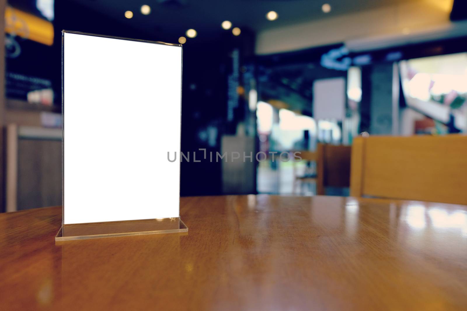 Mock up Menu frame standing on wood table in Bar restaurant cafe. space for text