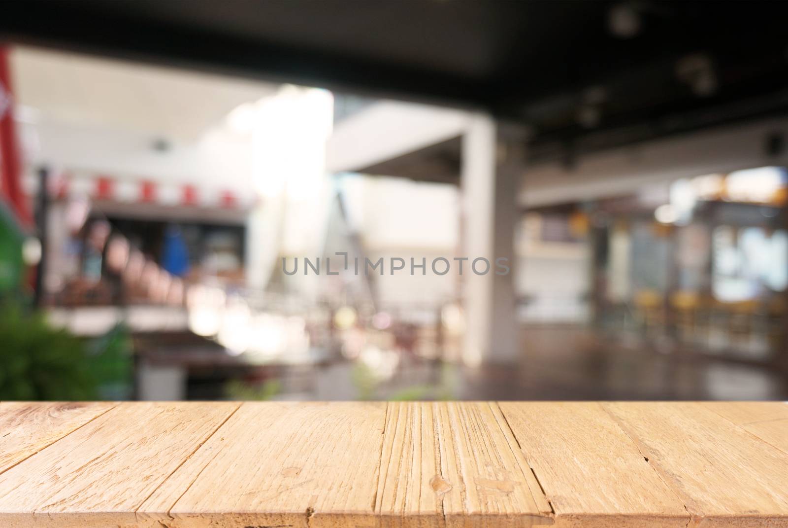 Empty dark wooden table in front of abstract blurred background of cafe and coffee shop interior. can be used for display or montage your products