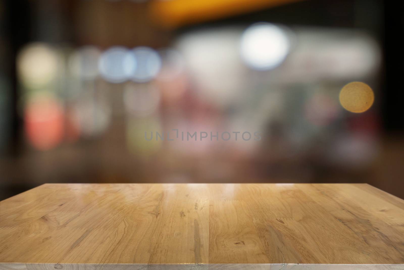 Empty dark wooden table in front of abstract blurred background of cafe and coffee shop interior. can be used for display or montage your products