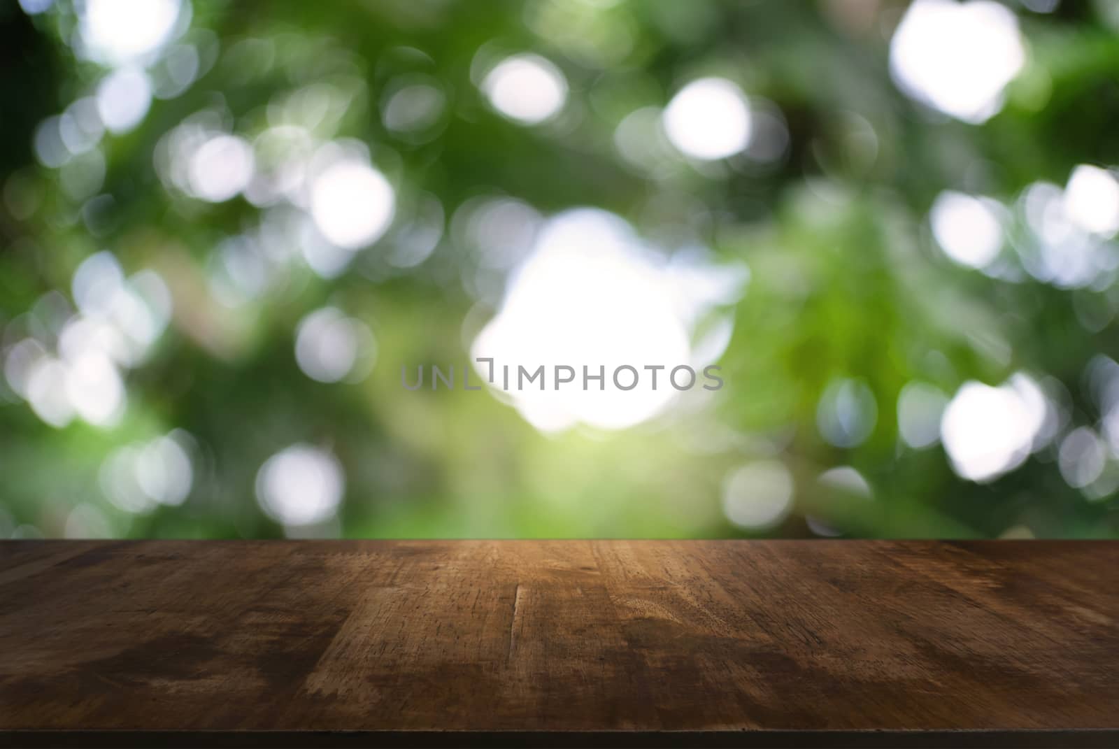 Image of dark wooden table in front of abstract blurred background of outdoor garden lights. can be used for display or montage your products.Mock up for display of product