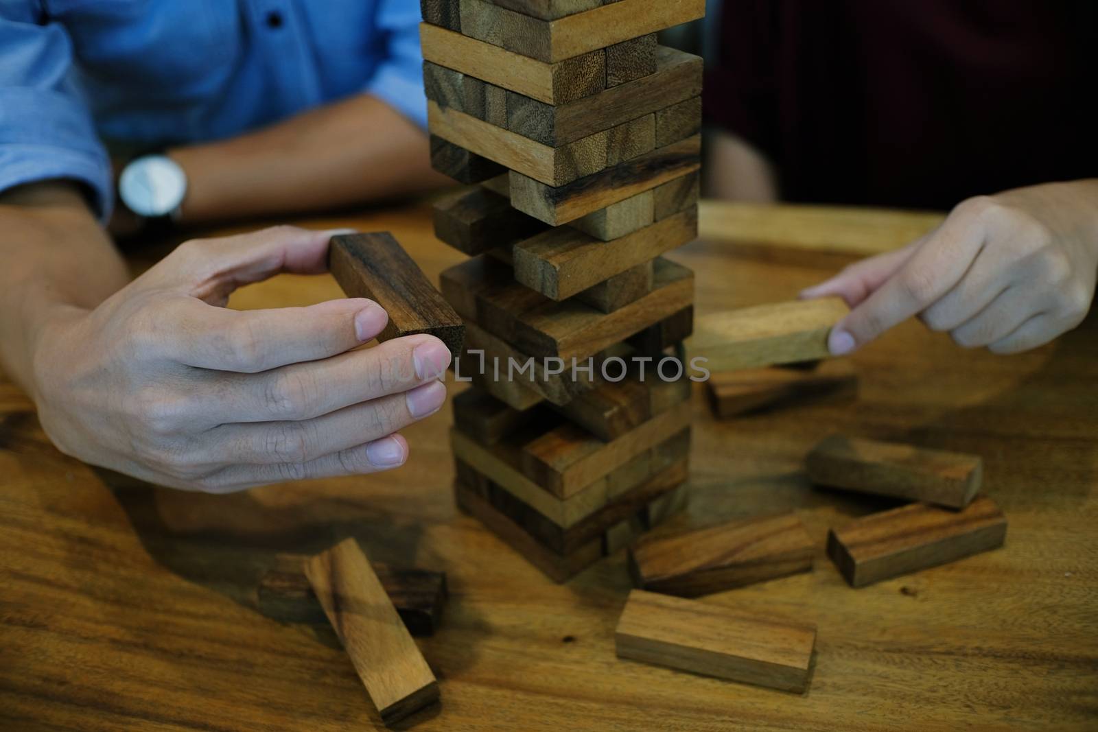 Group of Friends playing blocks wood game on the table folded puzzle