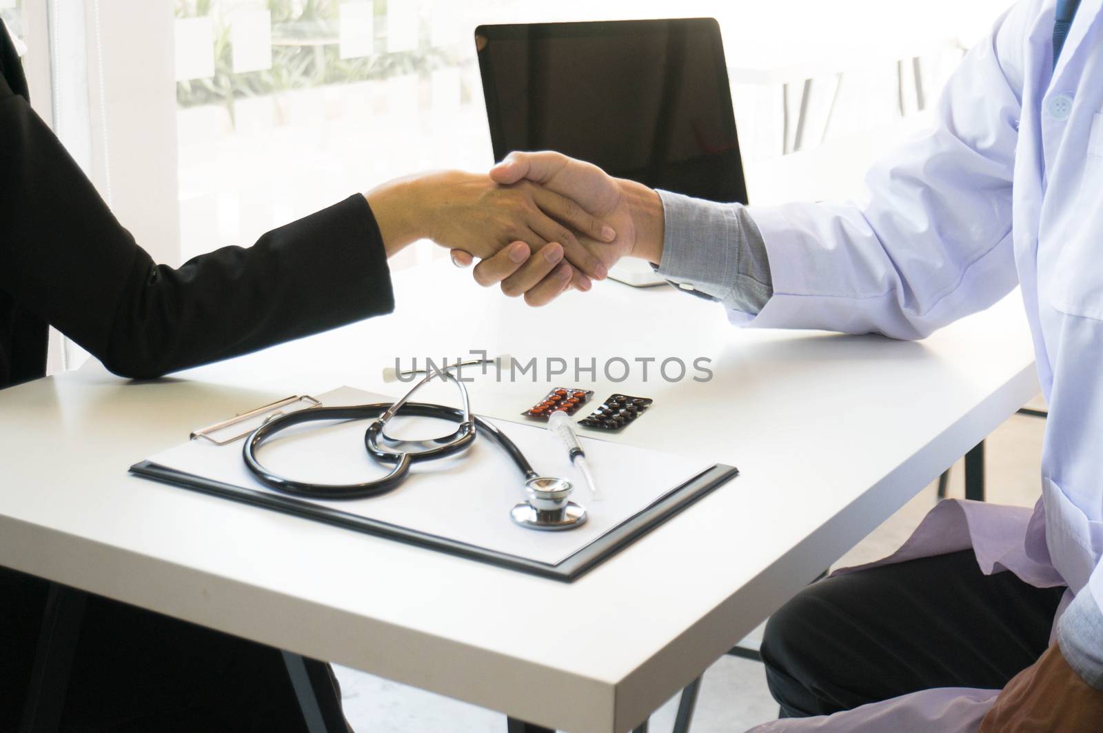 Doctor holding patient's hand, and reassuring his male patient helping hand concept.