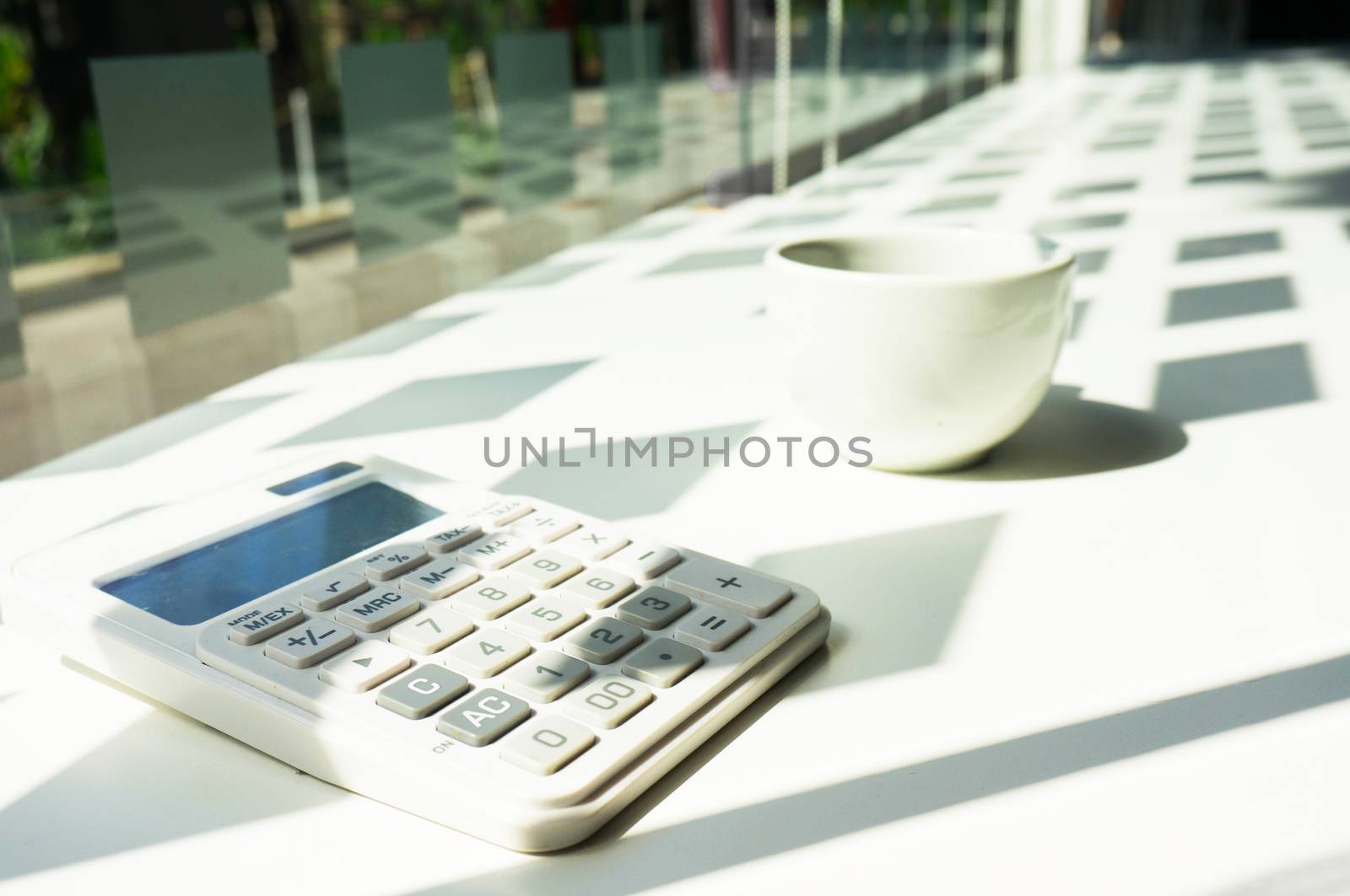 Calculator with coffee in office