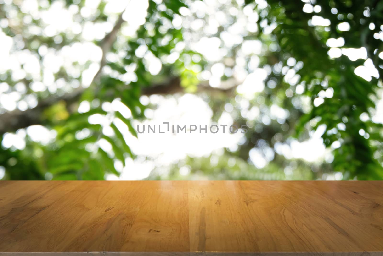 Image of dark wooden table in front of abstract blurred background of outdoor garden lights. can be used for display or montage your products.Mock up for display of product.