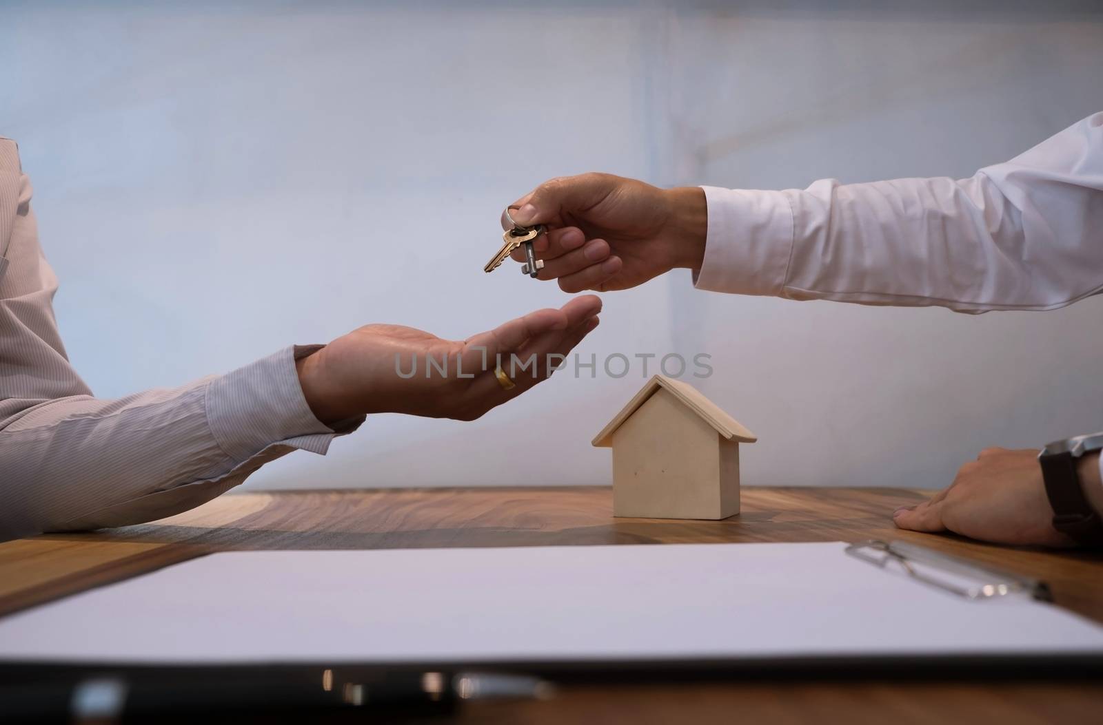 Real estate agent giving keys to customer after contract signatu by peandben