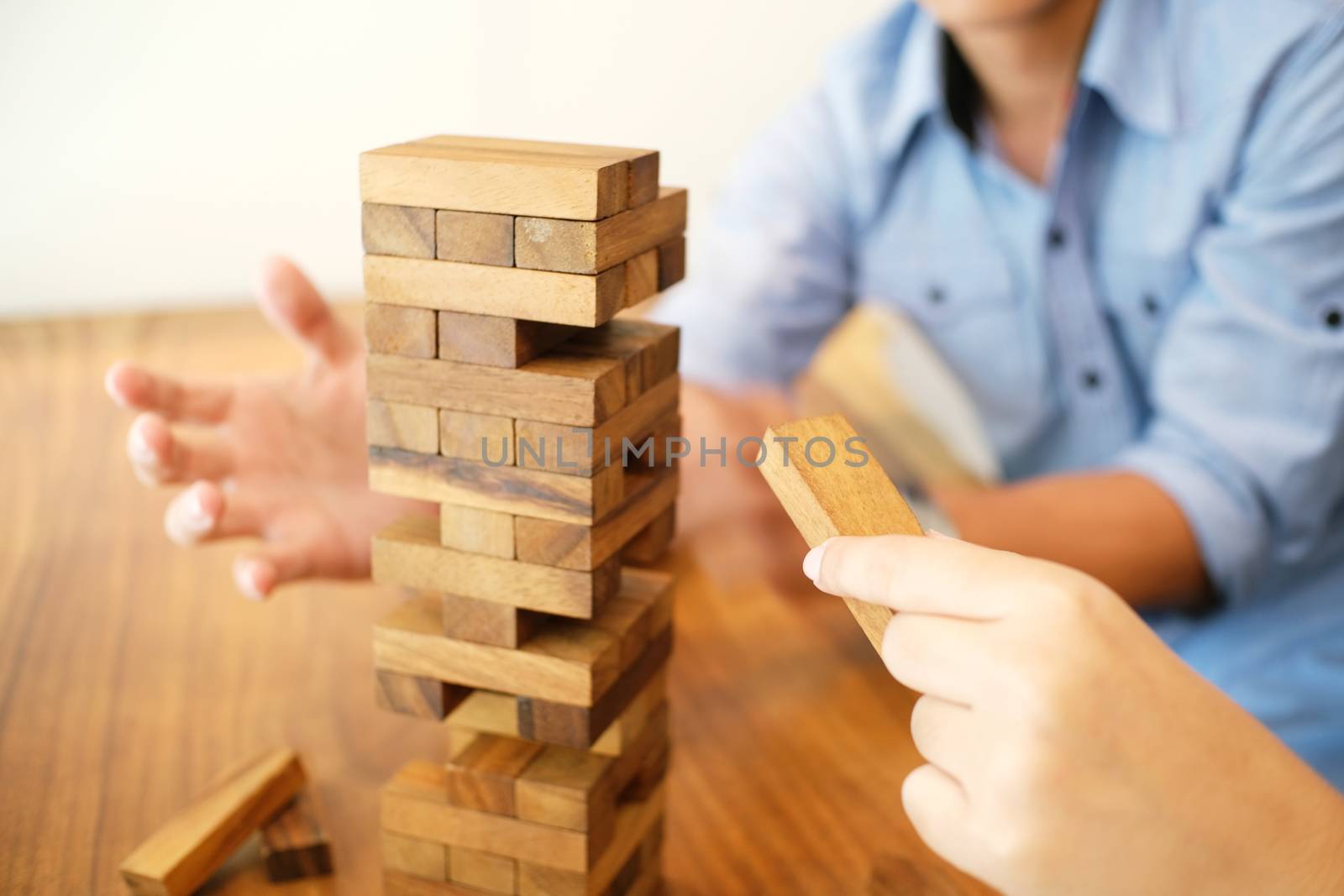 Group of Friends playing blocks wood game on the table folded puzzle