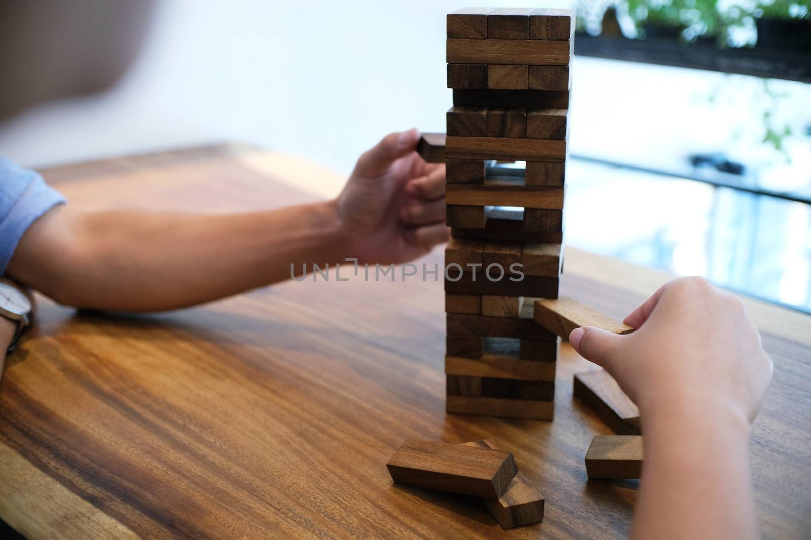 Group of Friends playing blocks wood game on the table folded pu by peandben