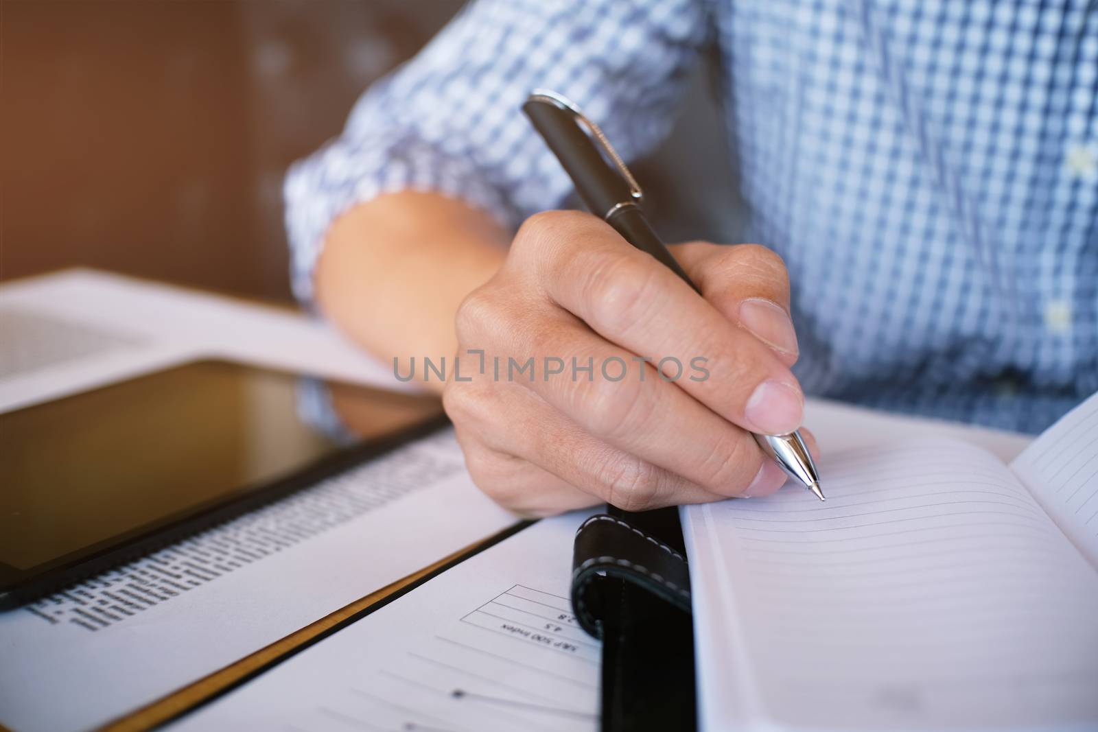 Man student writes information from portable tablet while prepar by peandben