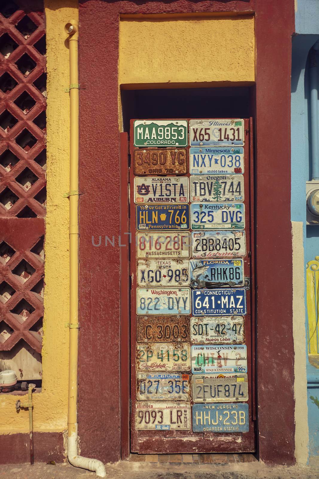 Colorful door decorated with car plates in Mexico at Isla Mujeres