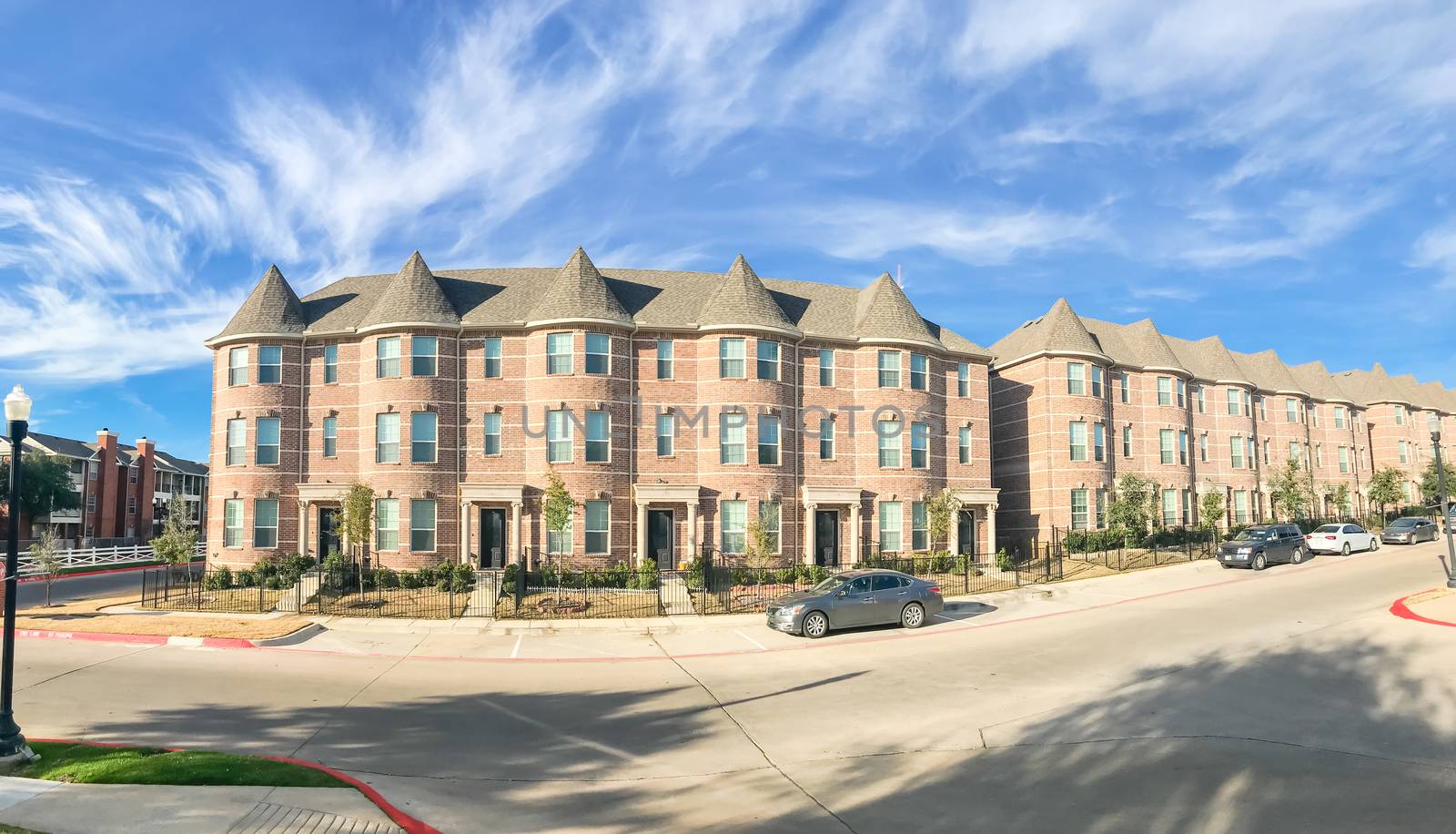 Panorama view new townhome apartment complex with cars park on street near Dallas, Texas, USA