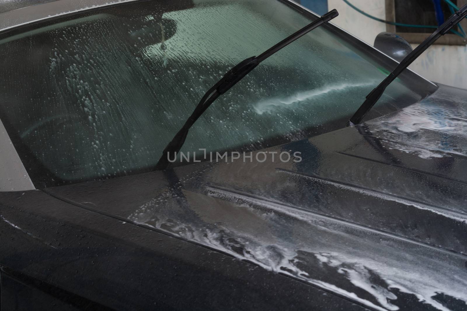 Manual car wash with pressurized water in the car wash outside.
