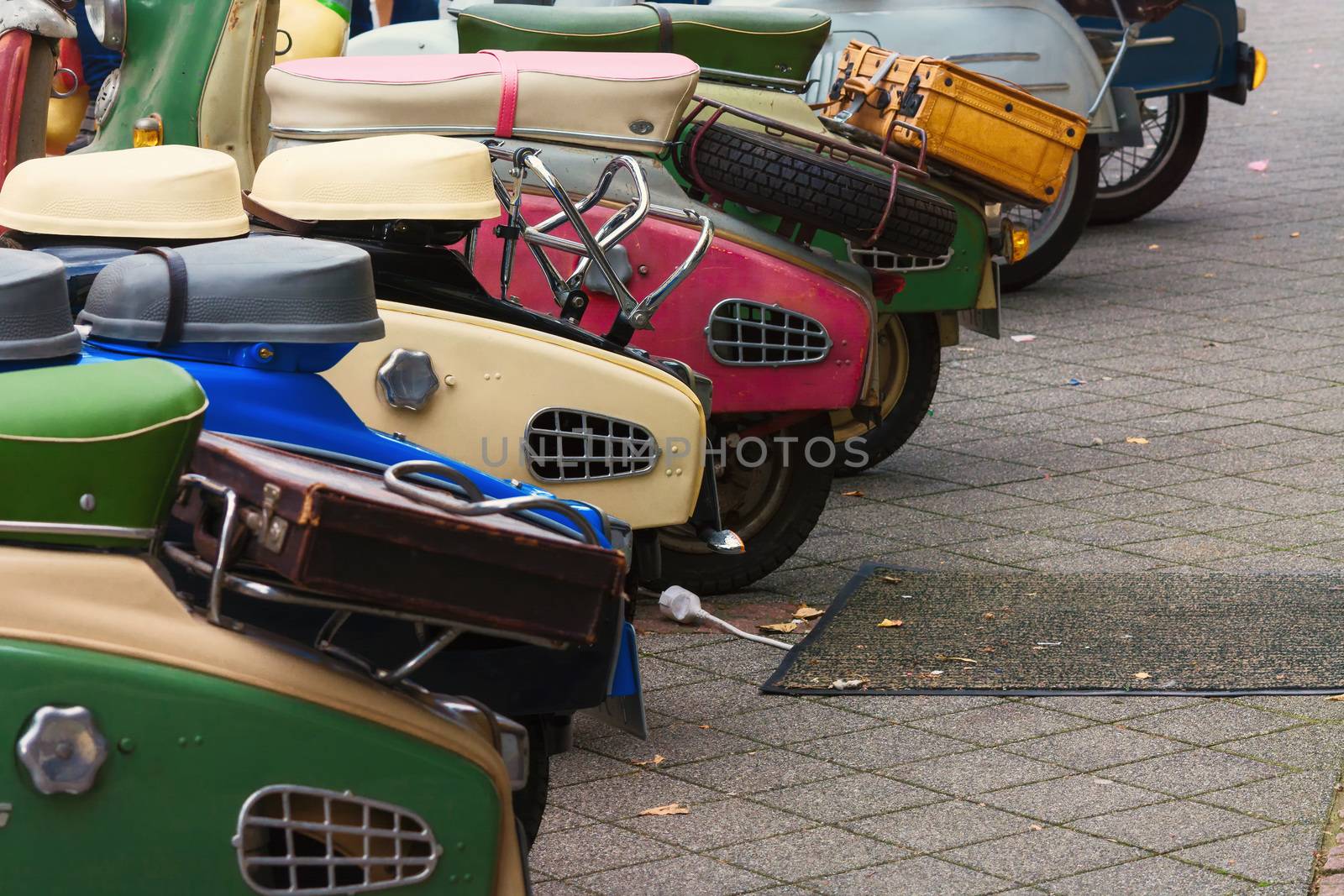 Various retro scooters line the road in a row.