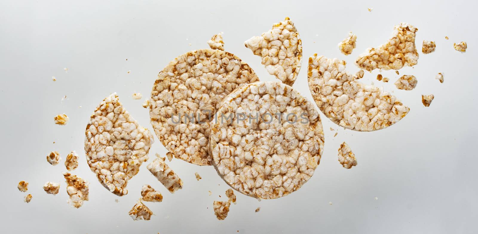 Broken puffed rice bread isolated on white background, crushed diet crispy round rice waffles