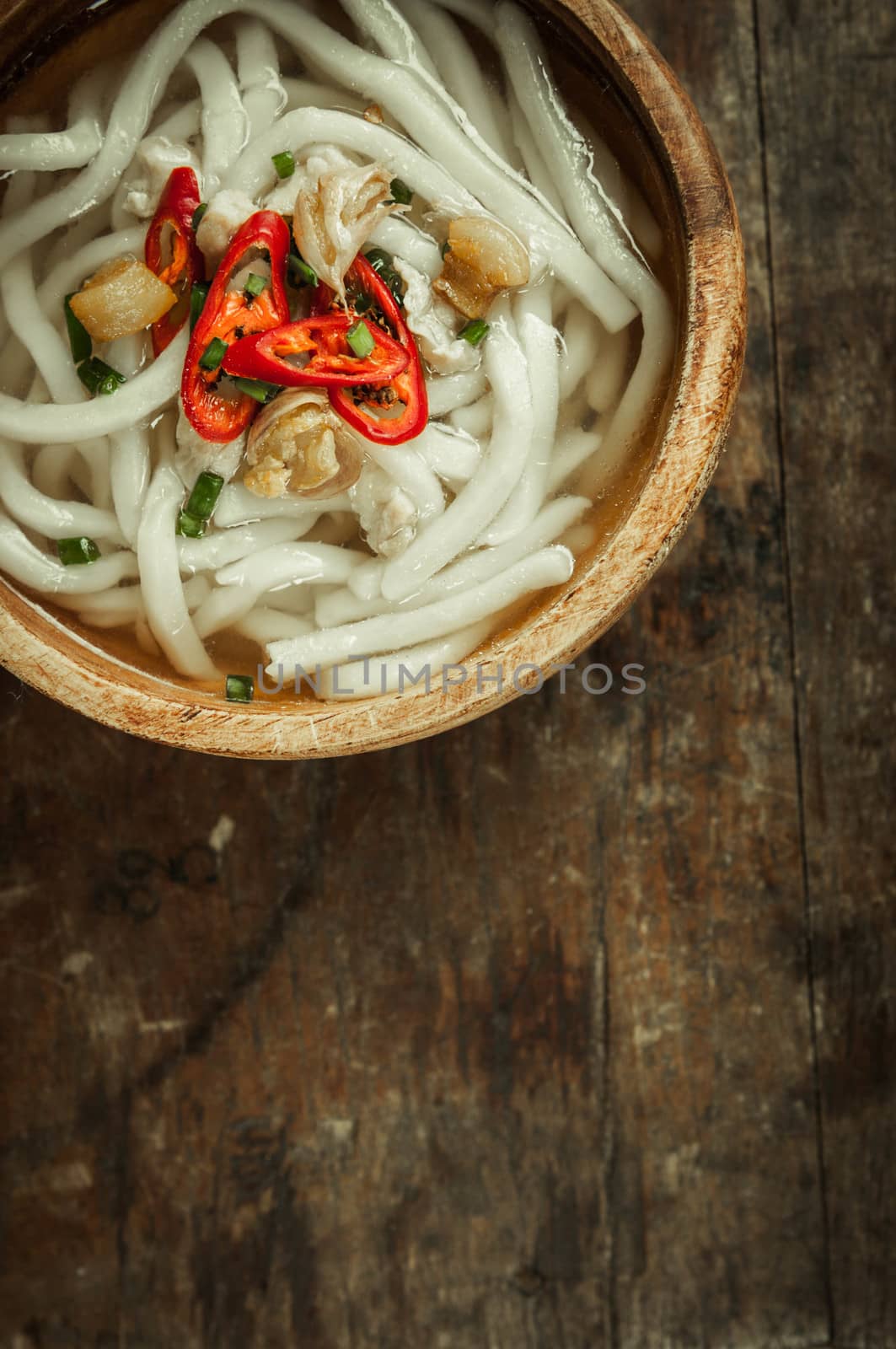 closeup of udon noodle in wood bowl on wooden floor background