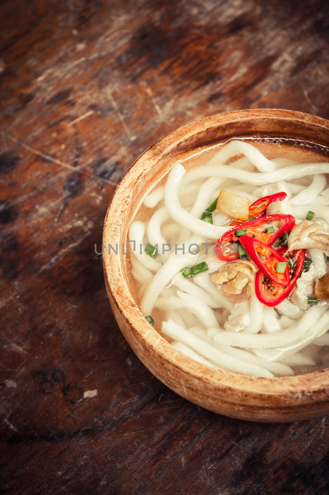 closeup of udon noodle in wood bowl on wooden floor