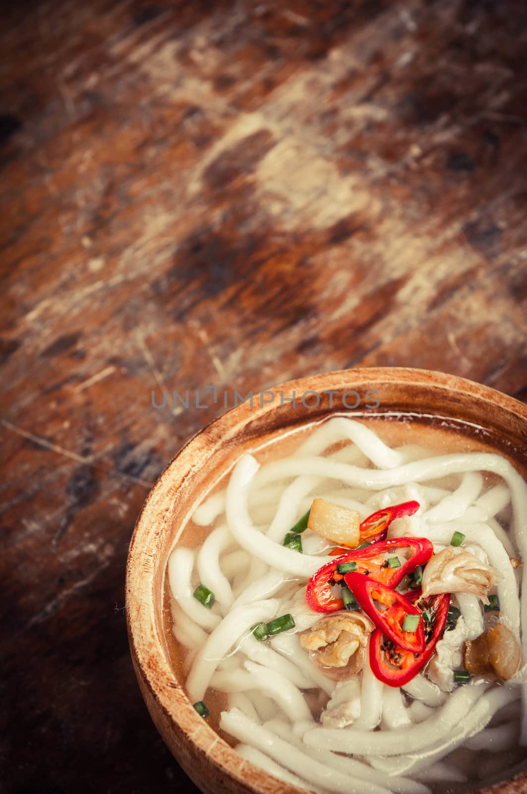 closeup of udon noodle in wood bowl on wooden floor