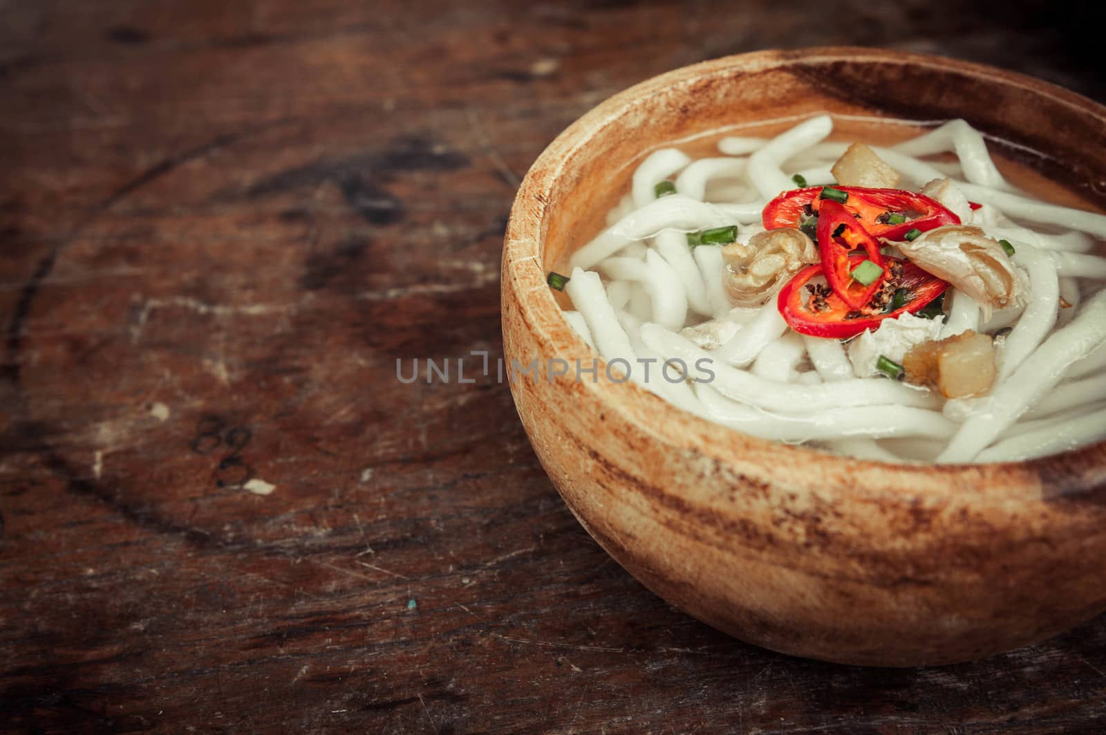 closeup of udon noodle in wood bowl on wooden floor background