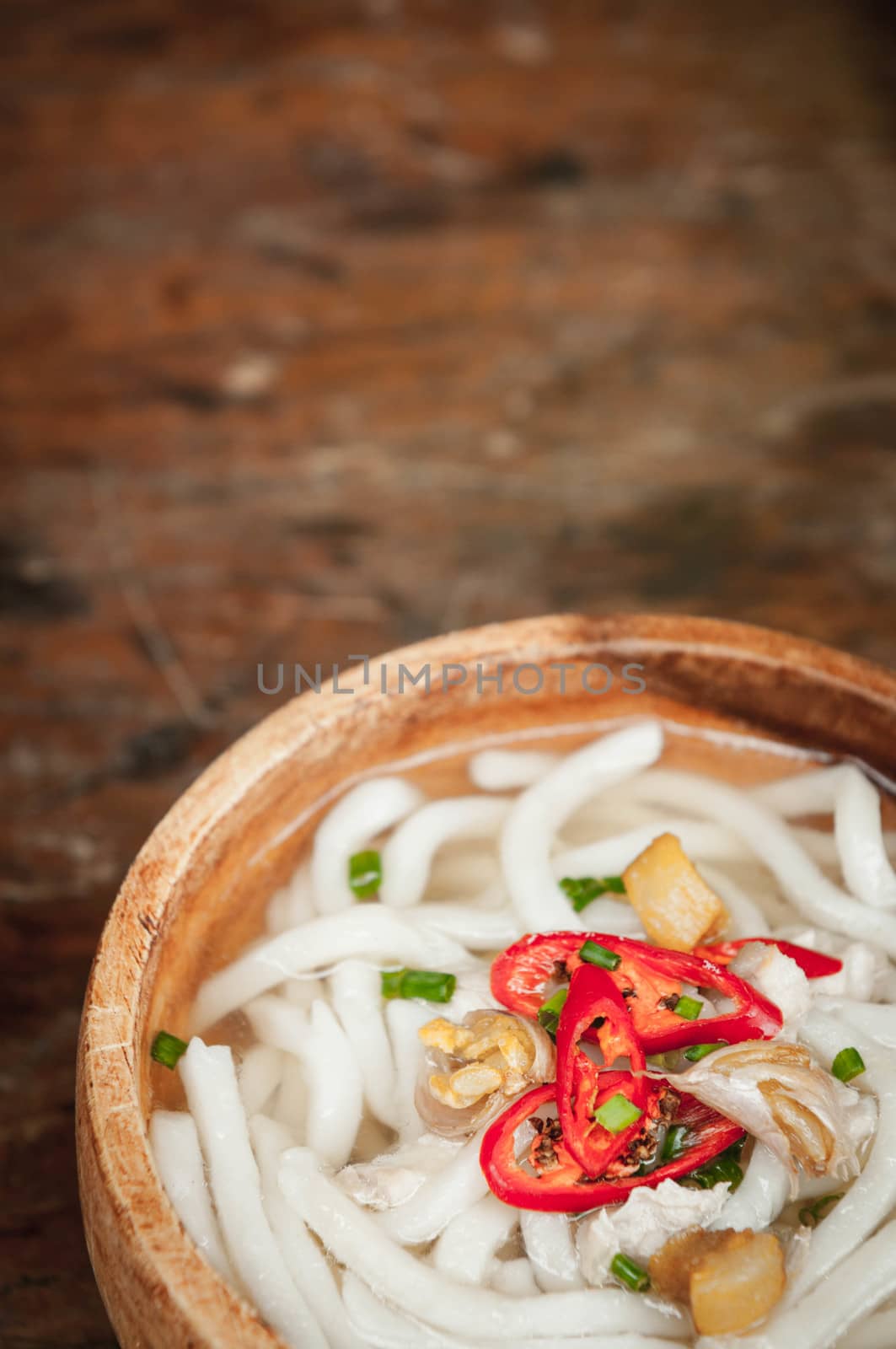 closeup of udon noodle in wood bowl on wooden floor background