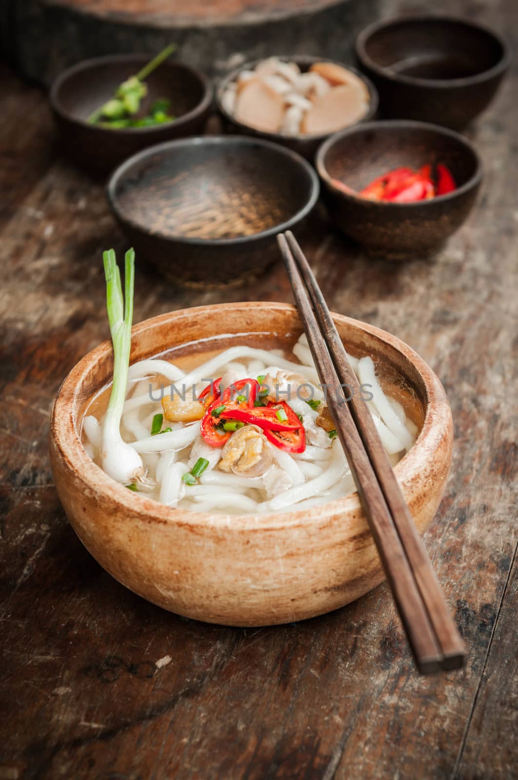 closeup of udon noodle in wood bowl on wooden floor