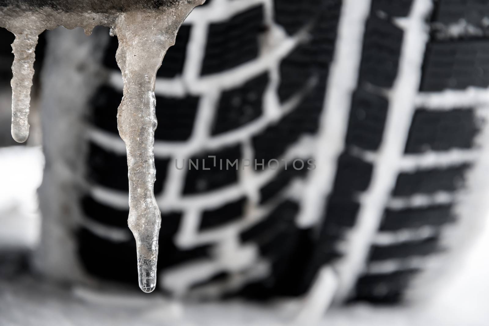 closeup of a tyre of a car with icicle in winter
