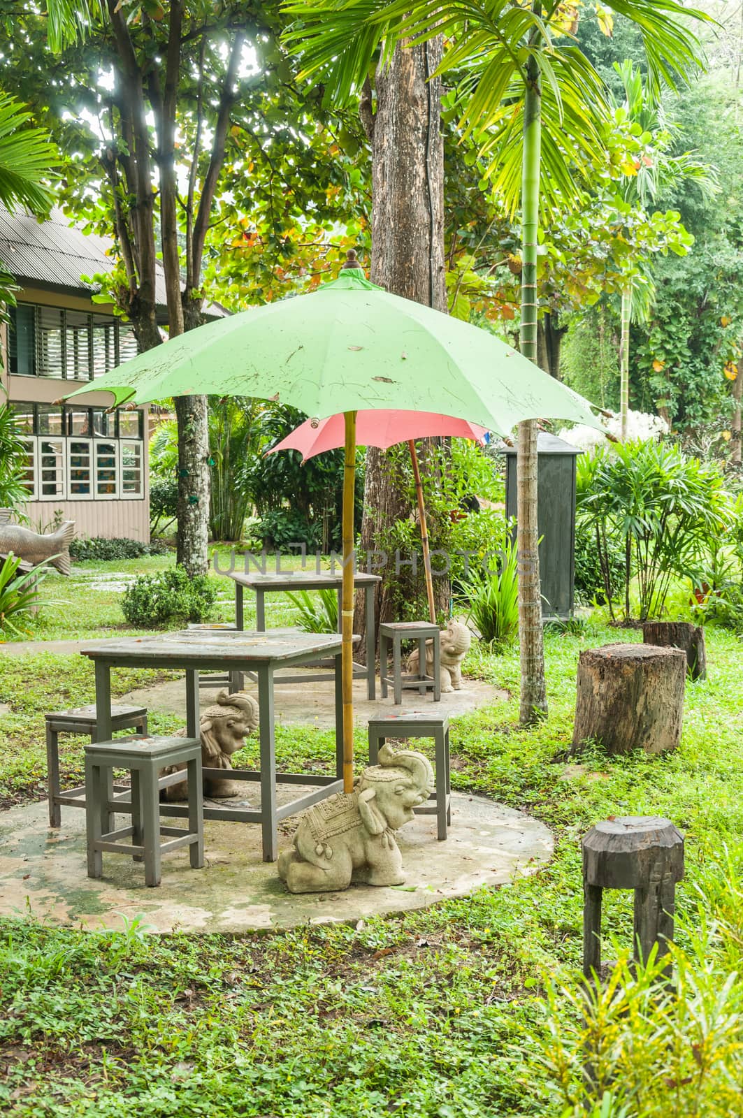 Table and green umbrella in the garden